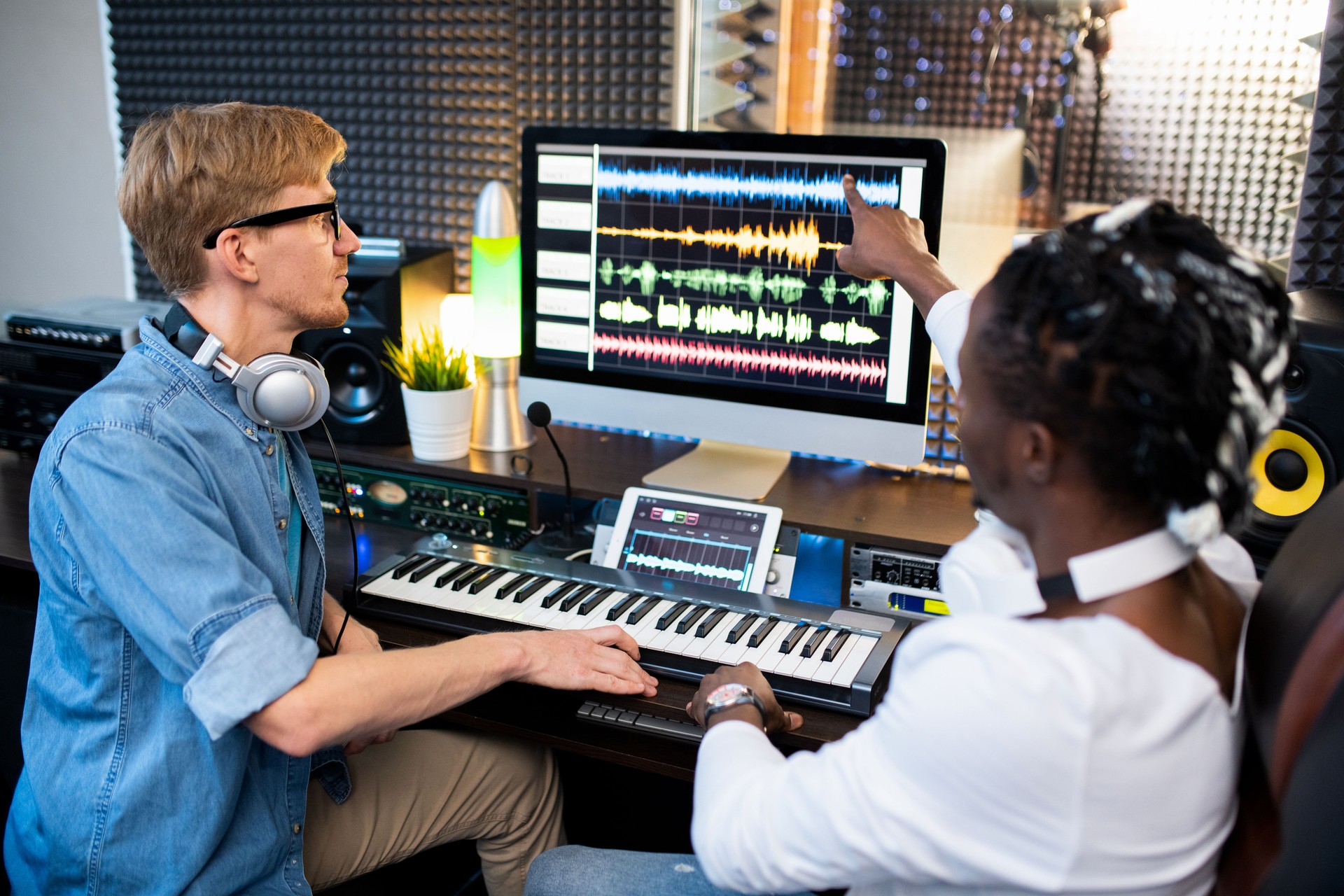 One of contemporary musicians pointing at sound waveform on computer screen